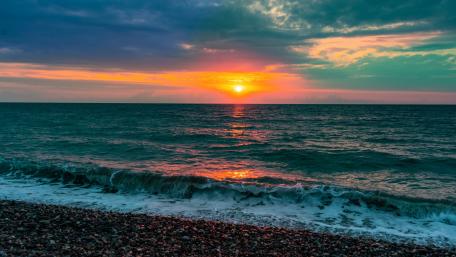 Serene Sunset Over Calm Sea Waves wallpaper
