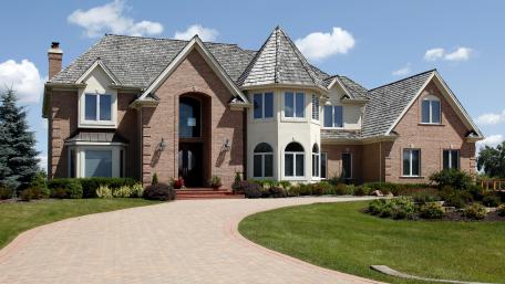 Elegant Brick Mansion Surrounded by Lush Gardens and Clear Skies wallpaper