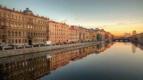 Serene Cityscape at Sunset Over Tranquil Waters wallpaper