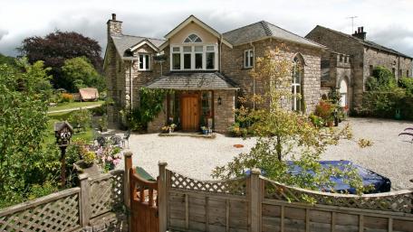 Charming Stone House Surrounded by Lush Greenery wallpaper