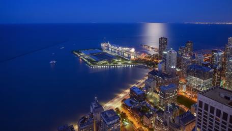 City at Dusk with Illuminated Skyline and Serene Water View wallpaper