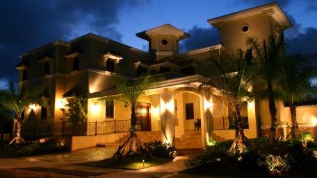 Elegant Nighttime Villa with Lush Surroundings and Soft Illumination wallpaper