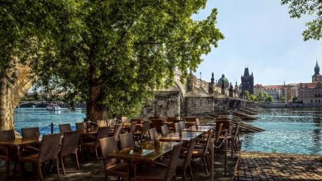 Charming Riverside Cafe in Prague's Scenic Beauty wallpaper
