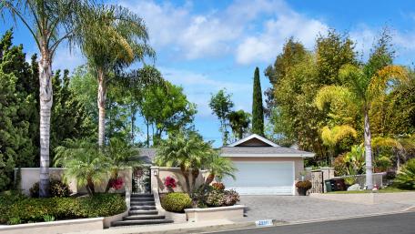 Charming Suburban Home Surrounded by Lush Vegetation wallpaper