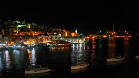 Serene Nighttime Harbor View with Boats and City Lights wallpaper