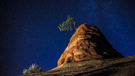 Majestic Starry Night Over Rocky Landscape wallpaper