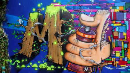 Vibrant Hand Graffiti on Blue Wall wallpaper