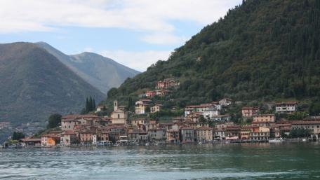 Serene Lakeside Village Amidst Mountains wallpaper
