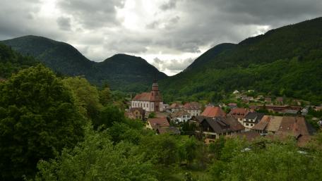 Serene Village Nestled in Majestic Mountains wallpaper