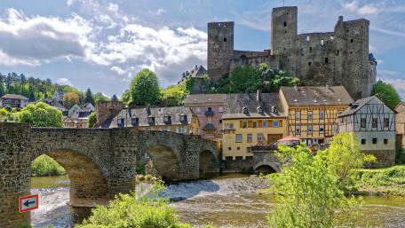 Picturesque Castle Overlooking a Charming River Town wallpaper
