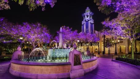Elegant Purple Fountain in a City Nightscape wallpaper