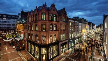 Charming Evening Cityscape with Vibrant Lights and Historic Architecture wallpaper