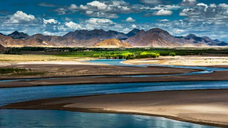 Serene River Landscape Under Dramatic Skies wallpaper