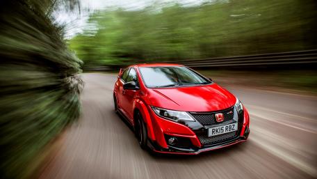 Dynamic Red Honda Racing on a Scenic Roadway wallpaper