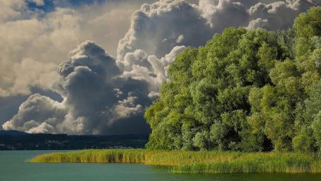 Majestic Clouds Over Serene Lake Scene wallpaper