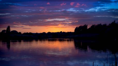 Serene Sunset Reflection Over Tranquil Lake wallpaper