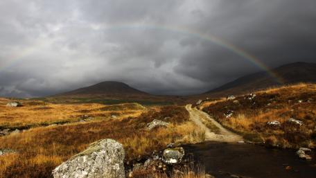 Serene Landscape Under a Rainbow Arching Over the Hills wallpaper