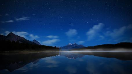 Serene Starry Night Over a Reflective Lake wallpaper