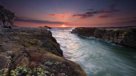 Serene Sunset Over Rocky Shoreline wallpaper