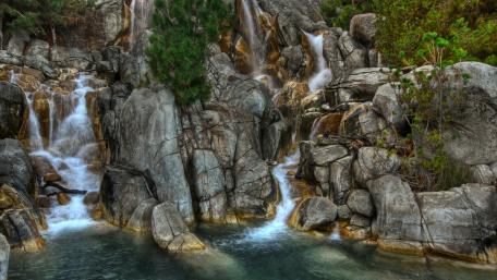 Tranquil Waterfall Amidst Rocky Terrain wallpaper