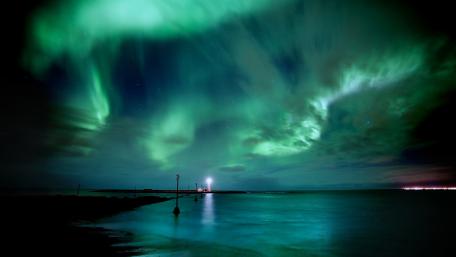 Majestic Northern Lights Over Serene Waters wallpaper