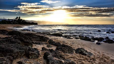 Serene Beach Sunset Over Rocky Shoreline wallpaper