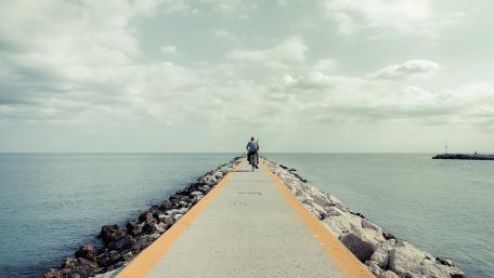 Serene Coastal Pathway Beneath a Cloudy Sky wallpaper