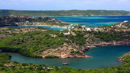 Serene Coastal Landscape with Vibrant Waters and Lush Greenery wallpaper