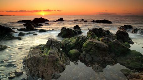 Serene Sunset over Rocky Shoreline wallpaper