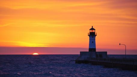 Lighthouse at Sunset Over the Ocean wallpaper