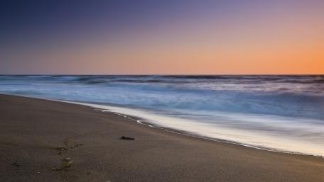 Serene Sunset Over Tranquil Beach Waves wallpaper