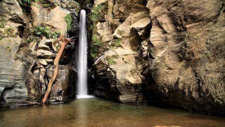 Majestic Waterfall Cascading from Rugged Cliffs wallpaper