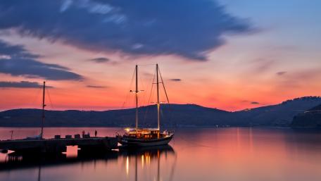 Serene Sunset by the Lake with a Sailing Ship wallpaper
