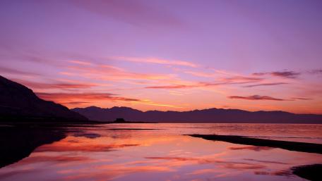 Enchanting Purple Sunset Over Tranquil Lake wallpaper