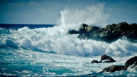Majestic Ocean Waves Crash Against Rocky Shoreline wallpaper