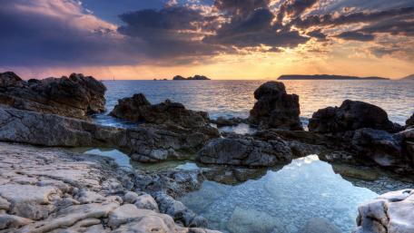 Serene Sunset Over Rocky Coastline wallpaper