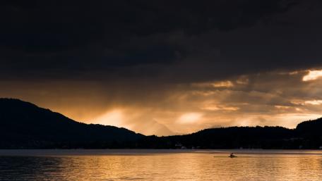 Serene Lake Beneath Dramatic Clouds wallpaper