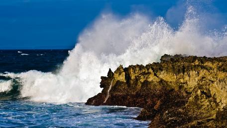 Majestic Waves Crashing Against Rocky Shores wallpaper