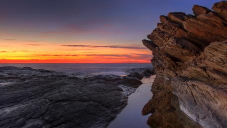 Majestic Sunset Over Rocky Seashore wallpaper