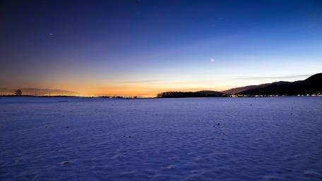 Serene Winter Night Over Snowy Horizon wallpaper