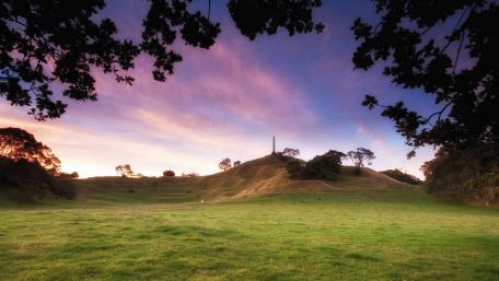 Serene Sunset Over Lush Green Hillside wallpaper