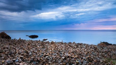 Serene Coastal Pebbles Under Blue Hour Sky wallpaper