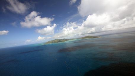 Serene Island View Beneath Cumulus Clouds wallpaper