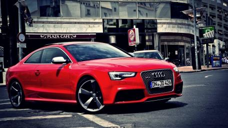 Vibrant Red Audi RS5 Takes Center Stage on City Streets wallpaper