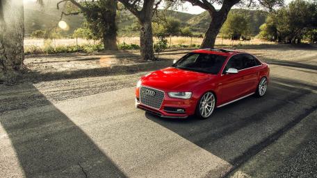 Sleek Red Audi on a Scenic Roadway wallpaper