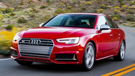 Sleek Red Audi in Motion on Scenic Roadway wallpaper