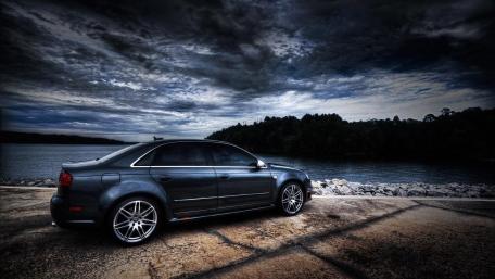 Sleek Car Against Dramatic Sky wallpaper