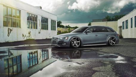 Sleek Audi Station Wagon in Urban Setting Reflecting on Wet Pavement wallpaper