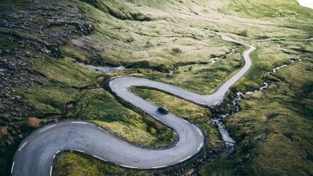 Curvy Road Through Lush Hillside Landscape wallpaper