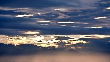 Majestic Clouds Embracing the Sky Over Mountains wallpaper